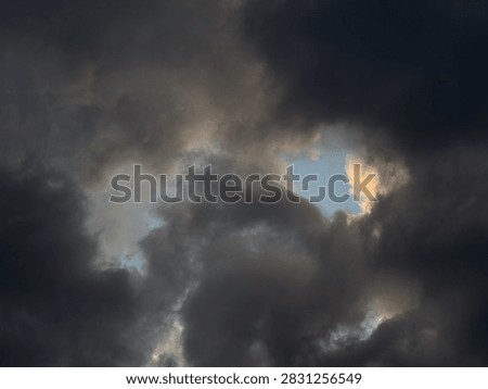 Dramatic view of dark storm clouds overcasting bright blue sky background before heavy rain, beautiful natural pattern of heavy grey cumulus thunderclouds and stormclouds before intense thunderstorm at summer day, climate and meteorology concept.
