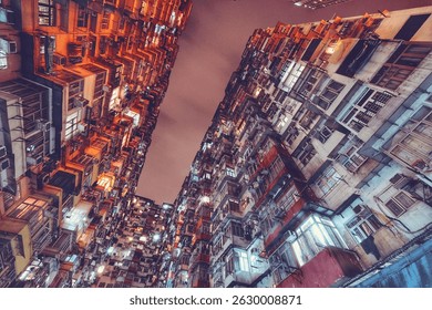 Dramatic view of densely packed apartment buildings in Hong Kong under a cloudy evening sky, showcasing urban architecture.