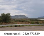 A dramatic view of an empty road with mountains in the background in Cochise County, Arizona