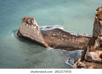 Dramatic view of the iconic chalk cliffs, known as the Falaise d'Aval and Falaise d'Amont, and natural rock formations in Etretat, Normandy, France.