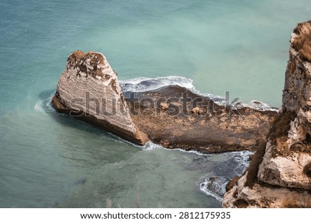 Dramatic view of the iconic chalk cliffs, known as the Falaise d'Aval and Falaise d'Amont, and natural rock formations in Etretat, Normandy, France.