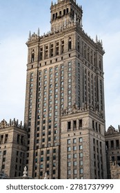 Dramatic view of an imposing stone skyscraper against a light sky, conveying strength and history for projects. Warsaw, Poland