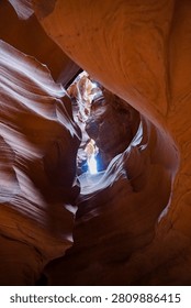 A dramatic view inside a sandstone slot canyon with smooth, sculpted rock walls illuminated by natural light. Ideal for travel, adventure, geology, and outdoor marketing content.