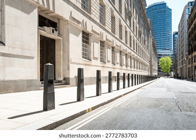 Dramatic view of a line of security bollards located outside a central London government building in Pimlico. The bollards act as perimeter security for unauthorised vehicles in the area.