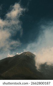 Dramatic view of Mount Etna's peak against a moody sky, highlighting the raw power and majestic beauty of Sicily's active volcano.