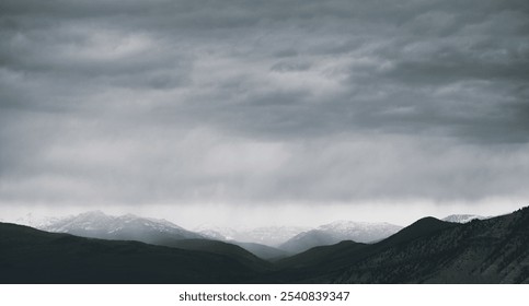 A dramatic view of mountains under dark, cloudy skies.