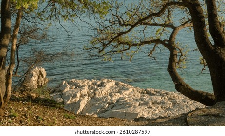 Dramatic view of the ocean with rocky cliffs rising above the waves, creating a stunning natural landscape along the coastline.