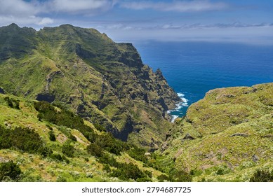 Dramatic view over the rugged volcanic cliffs and green slopes of Anaga dropping steeply into the Atlantic ocean, Tenerife