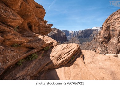 Dramatic view of sandstone cliffs and valleys under a bright blue sky, evoking awe and adventure