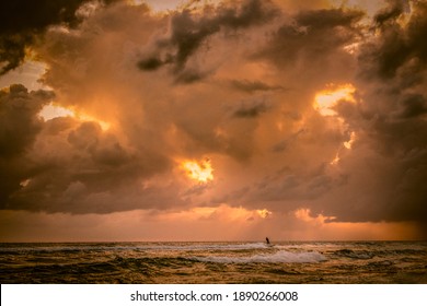 Dramatic view of sky and a surfer