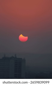 Dramatic view of a solar eclipse as the moon passes in front of the sun, casting a dark shadow with a glowing corona. A rare celestial event captured in a striking, high-contrast sky.