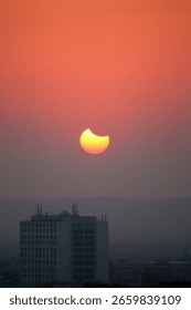 Dramatic view of a solar eclipse as the moon passes in front of the sun, casting a dark shadow with a glowing corona. A rare celestial event captured in a striking, high-contrast sky.