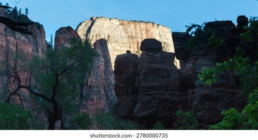 Dramatic view of sunlit rock formations, a majestic desert panorama under a clear blue sky