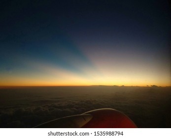 Dramatic View of Sunset Above the Clouds from Airplane Window