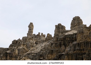 Dramatic view of Tre Cime di Lavaredo peaks framed through the entrance of a historical mountain cave or bunker in the Dolomites.
