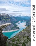 A dramatic view from Trolltunga, Norway, showcasing a winding fjord snaking through the rugged mountains.