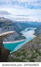 A dramatic view from Trolltunga, Norway, showcasing a winding fjord snaking through the rugged mountains.