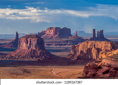 Dramatic views of Monument Valley in Navajo Nation with golden light at sunset 
