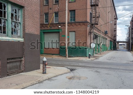 Dramatic vintage street scene with abandoned red brick warehouses in a depressed blue collar industrial area of St. Louis Missouri