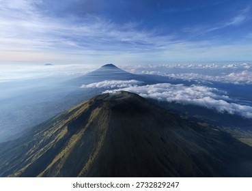 Dramatic Volcanic Landscape: Towering Mountains Pierce the Sky in an Aerial Panorama of Indonesia