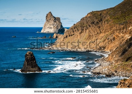 Dramatic volcanic rock formations rise from the deep blue Atlantic Ocean along the wild Anaga Mountains coast