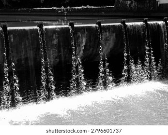 Dramatic Waterfall Cascading Over Dam in Monochrome