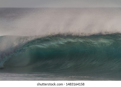 dramatic wave breaking in golden light at sunset