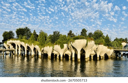 dramatic white clouds and bright blue sky over Little Island park on the Hudson River in New York City