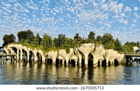 dramatic white clouds and bright blue sky over Little Island park on the Hudson River in New York City