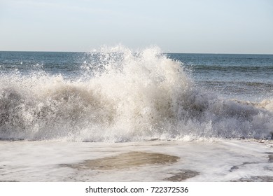 Dramatic white waves splashing. Clear blue skies on a serene day out at sea.  Huge crashing waves rolling in violently