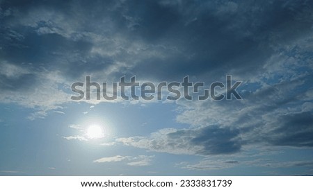 The dramatic winter landscape is enhanced by the puffy clouds against the blue and overcast sky, timelapse