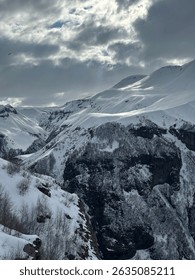 Dramatic winter mountain landscape under moody sky