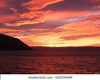a dramatic winter sunset at Catacol bay on the Isle of Arran,Scotland.Looking over to the Kintyre peninsula on Argyll.