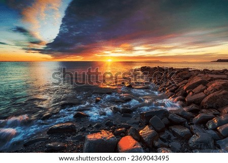 Dramatic winter sunset over a rocky outcrop at Kimmeridge Bay on the Dorset coastline
