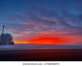 Dramatic Winter Sunset Over Snow-Covered Prairie Fields