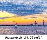 Dramatic yellow orange pink and purple sunset with Claiborne Pell Newport Bridge sailboat and clouds Newport, Rhode Island, USA, September 2009.