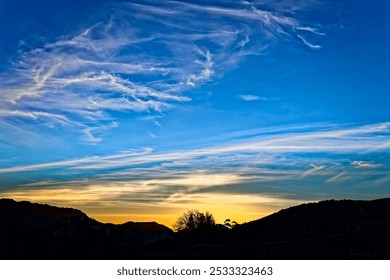 Dramatic yellow sunset over silhouetted mountains with blue sky and white clouds on the Bo-Piketberg mountain plateau in the Western Cape, South Africa - Powered by Shutterstock