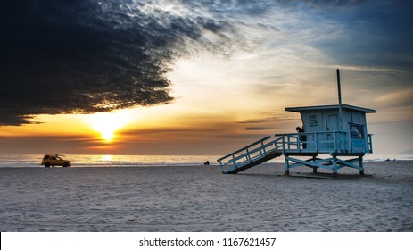 Dramatic Zuma Beach Sunset, Lifeguard Tower In Foreground, Lifeguard Car In Background.  Empty Beach During Winter.