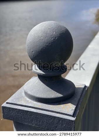 Dramatically lit gray railing finial