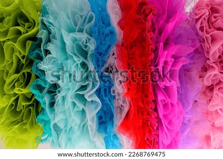 draped background of colorful powdery fabric in the form of tulle, texture textile surface. Texture background from the airy fabric of the dress. Copy space for text about design and fashion. 