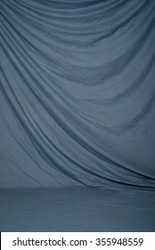 Draped Canvas Or Muslin Fabric Cloth Studio Backdrop Or Background, Suitable For Use With Portraits, Products And Concepts. Muted Blue Color.