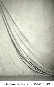 Draped Canvas Or Muslin Fabric Cloth Studio Backdrop Or Background, Suitable For Use With Portraits, Products And Concepts. Light Gray Color.