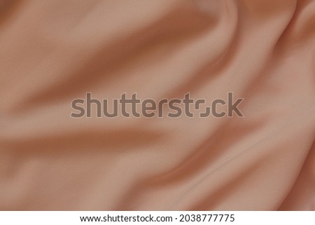 Draped peachy polyester fabric as a background for design