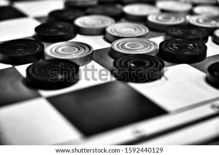 Draughts game, pieces on the board - black and white image