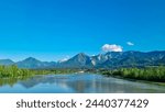 Drava river with panoramic view of majestic mountain ridges of Karawanks and Julian Alps, Carinthia, Austria, Europe. Idyllic landscape in Austrian Alps. Natural wilderness in summer. Wanderlust