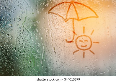 draw sun holding umbrella natural water drops glass window background
