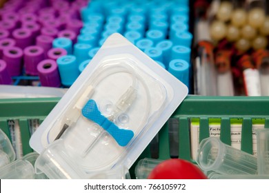 A drawer of blood collection tubes and a prominent blood collection needle in package with background blurred. 