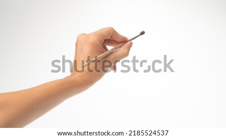 Drawing brush in a woman's left hand, gesture draws left-handed