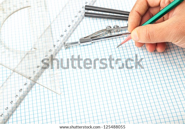 drawing compass , pencil, and ruler in the grid\
sheet studio shoot