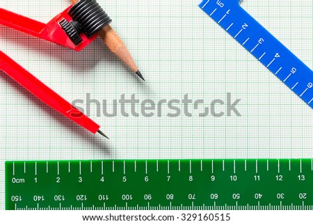 Drawing Compasses and Ruler on green graph paper with copy space
